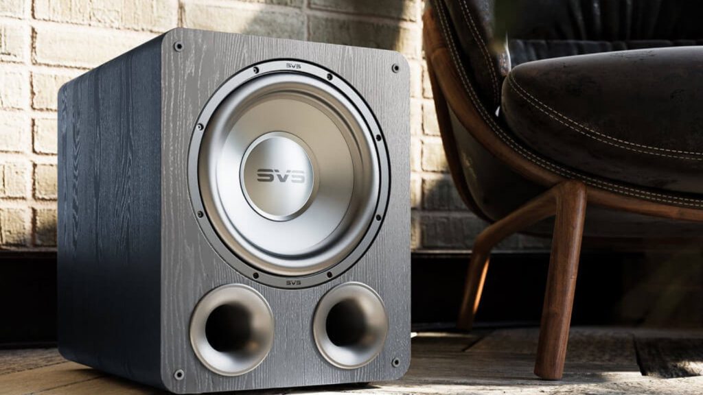 SVS PB-1000 Pro ported subwoofer in black ash beside a leather chair