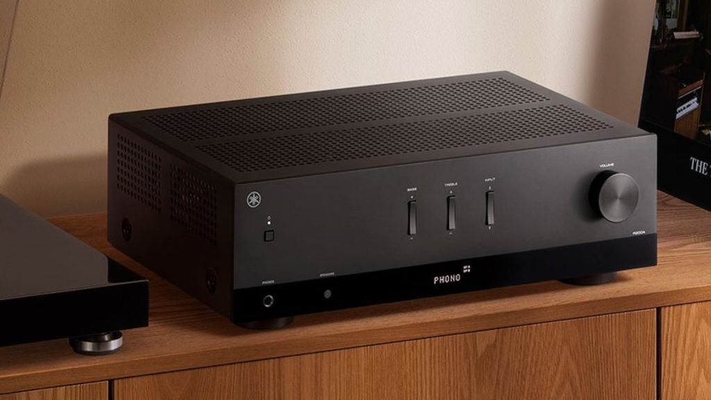 Yamaha R200A stereo receiver in black on a wooden sideboard next to a turntable and records